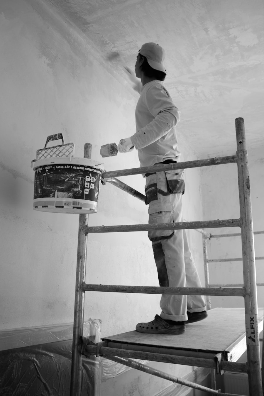 Pintor a pintar uma parede com rolo